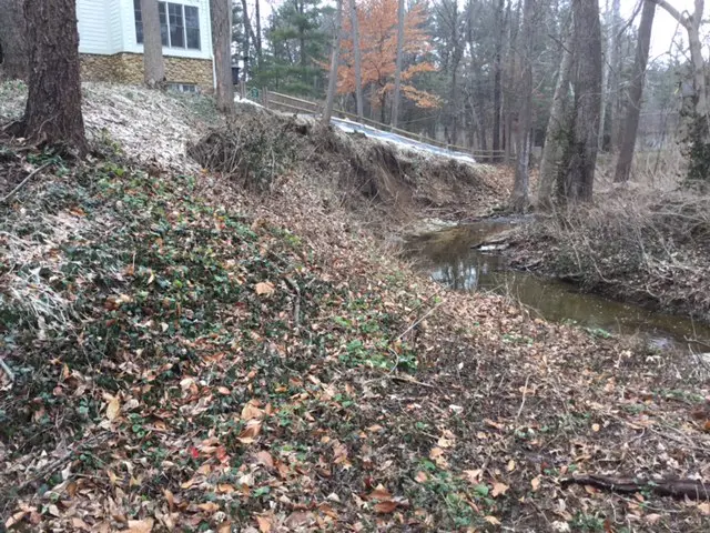 A view of a stream from the side of a house.