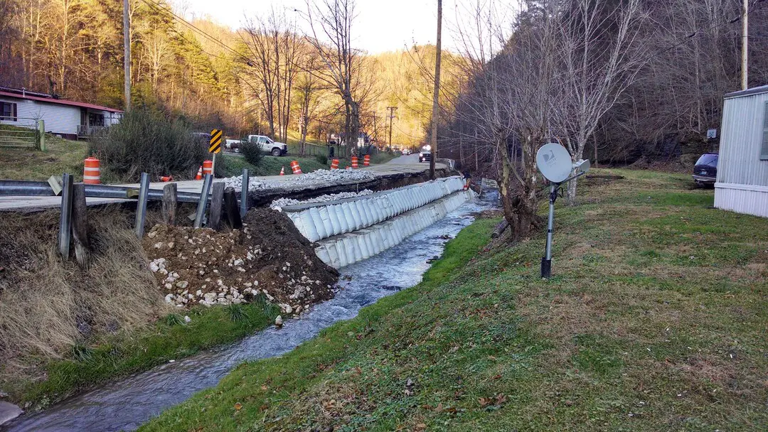 A stream of water flowing down the side of a road.