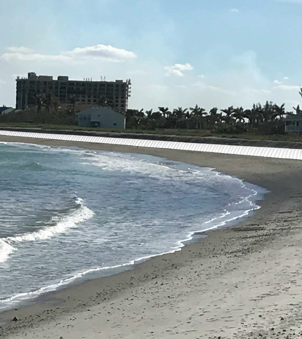 A beach with waves coming in from the ocean.