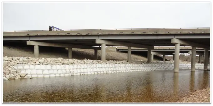 A river with some water and a bridge